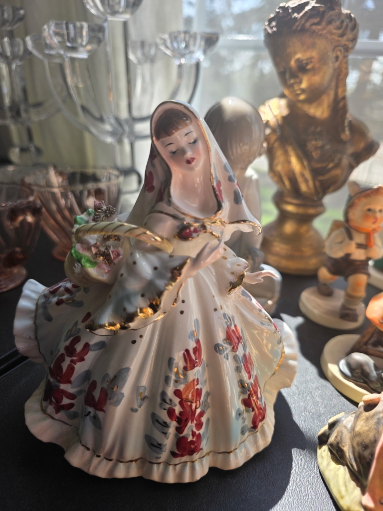 Porcelain figurine and vintage collectibles at a Compass Rose estate sale