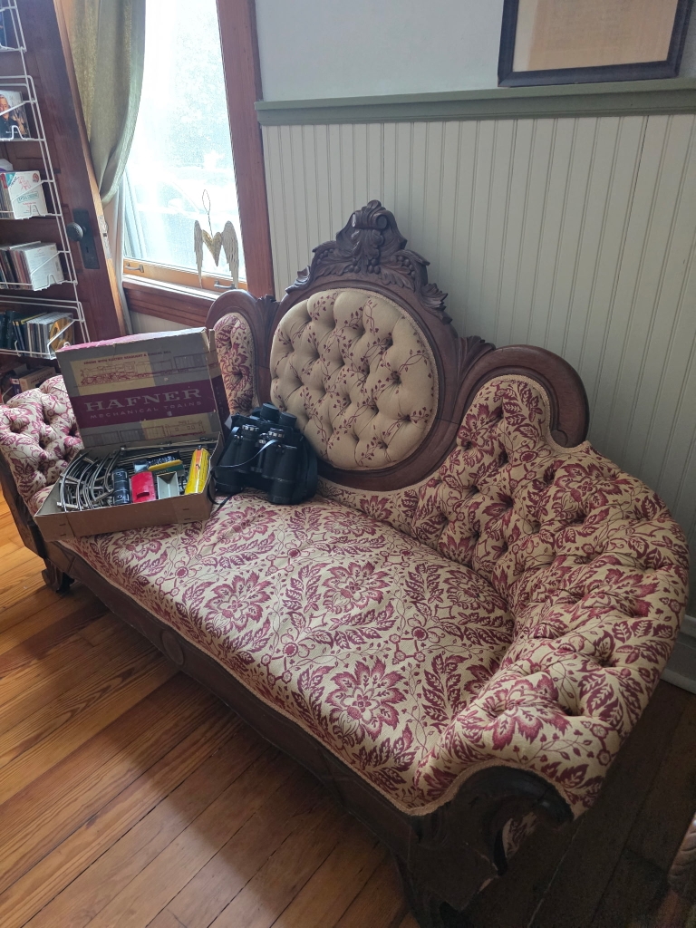 Ornate antique settee with floral upholstery at an estate sale